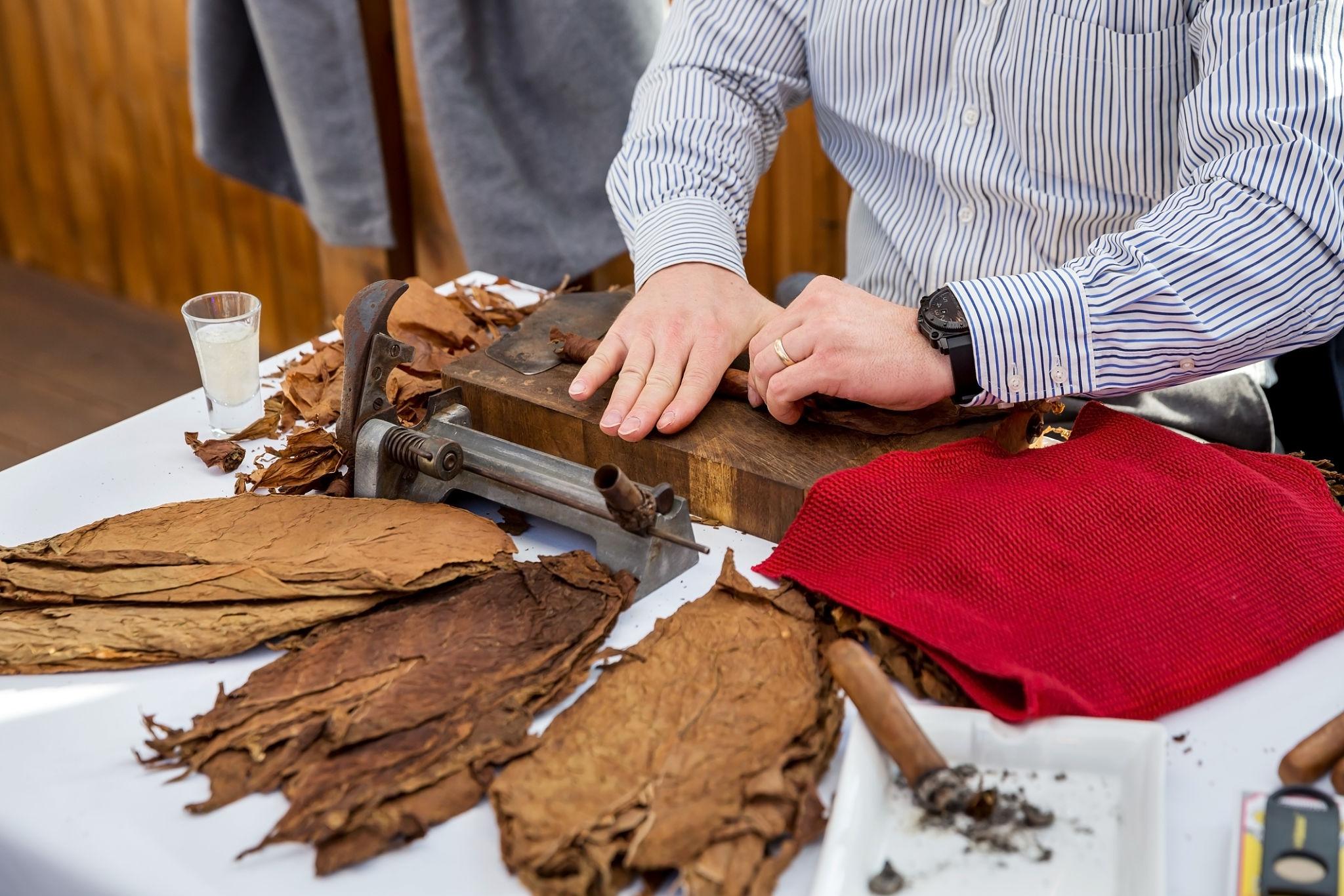 A relaxed cigar-and-drink pairing on a dark table